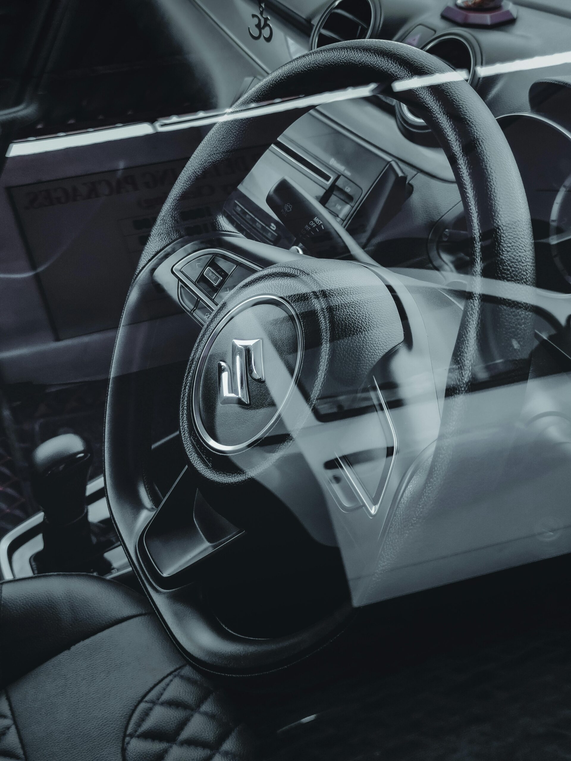 High-resolution close-up of a modern car interior featuring a steering wheel and dashboard components.