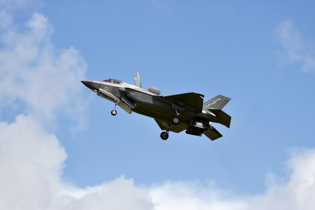 F-35 Lightning II military jet flying in clear skies over England.