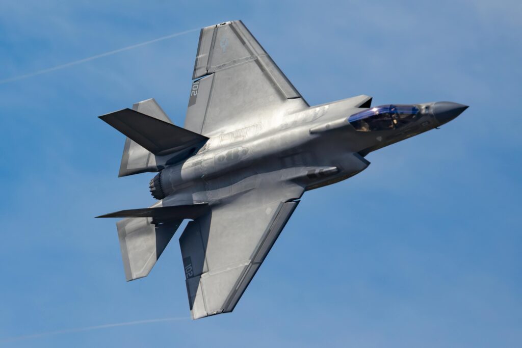 F-35 Lightning II fighter jet soaring through a clear blue sky.