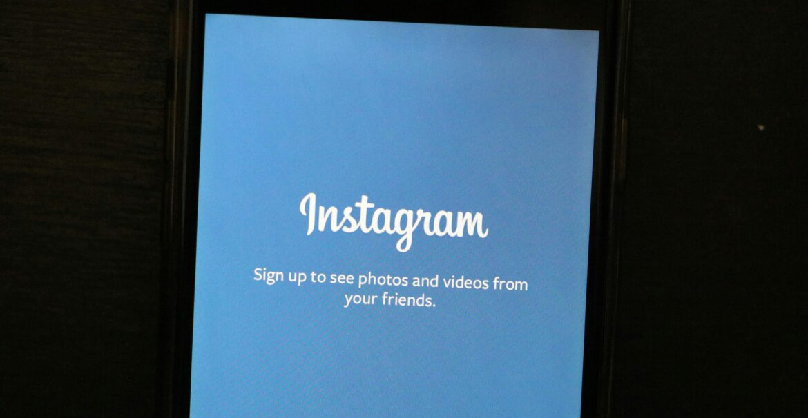 Close-up of a smartphone displaying the Instagram app welcome screen, inviting users to sign up.