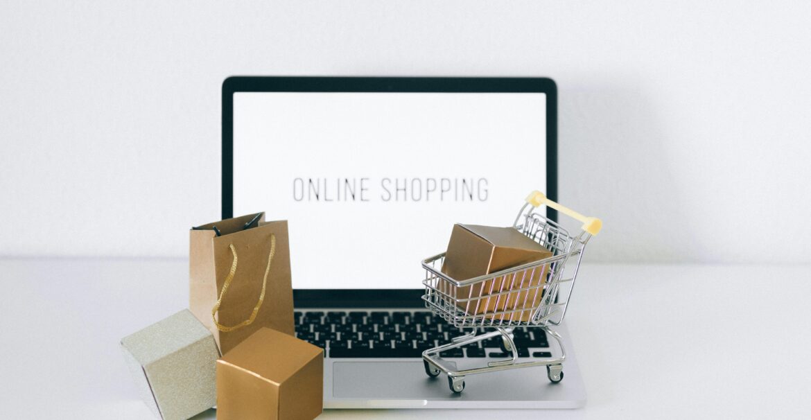 Laptop displaying online shopping with boxes and cart, representing ecommerce.